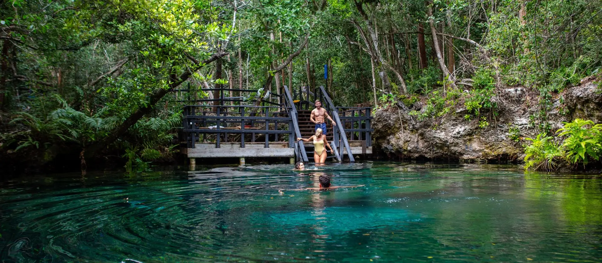 Grupo de turistas nadando en laguna natural de la Reserva Ojos Indígenas