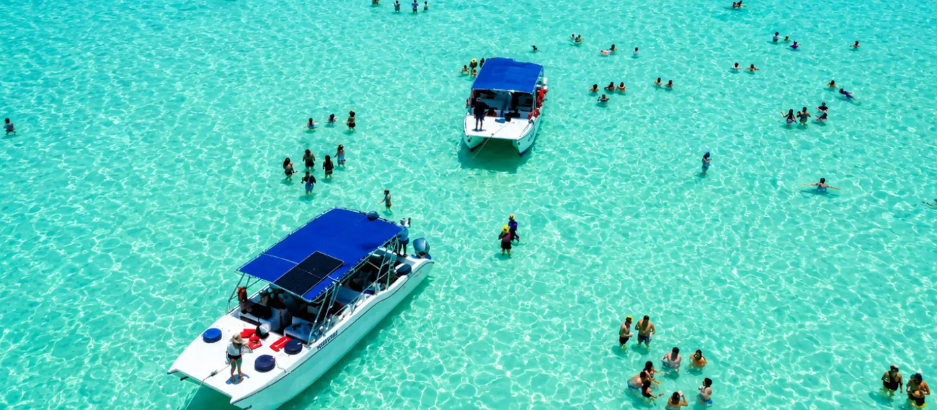 Vista aérea de la Piscina Natural de Isla Saona con turistas disfrutando de aguas turquesas.